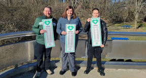 Pictured from left to right, are Zach Sokolowski, Tracy Rocco, and Nic Tobin, professionals who work in Michigan Medicine lab settings. They are holding posters placed across Michigan Medicine facilities, listing all of the job descriptions that UMMAP represents.